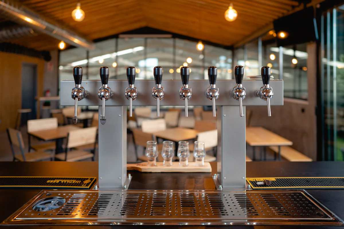 Beer taps inside the Cervezas Althaia taproom with terrace and brewhouse views.