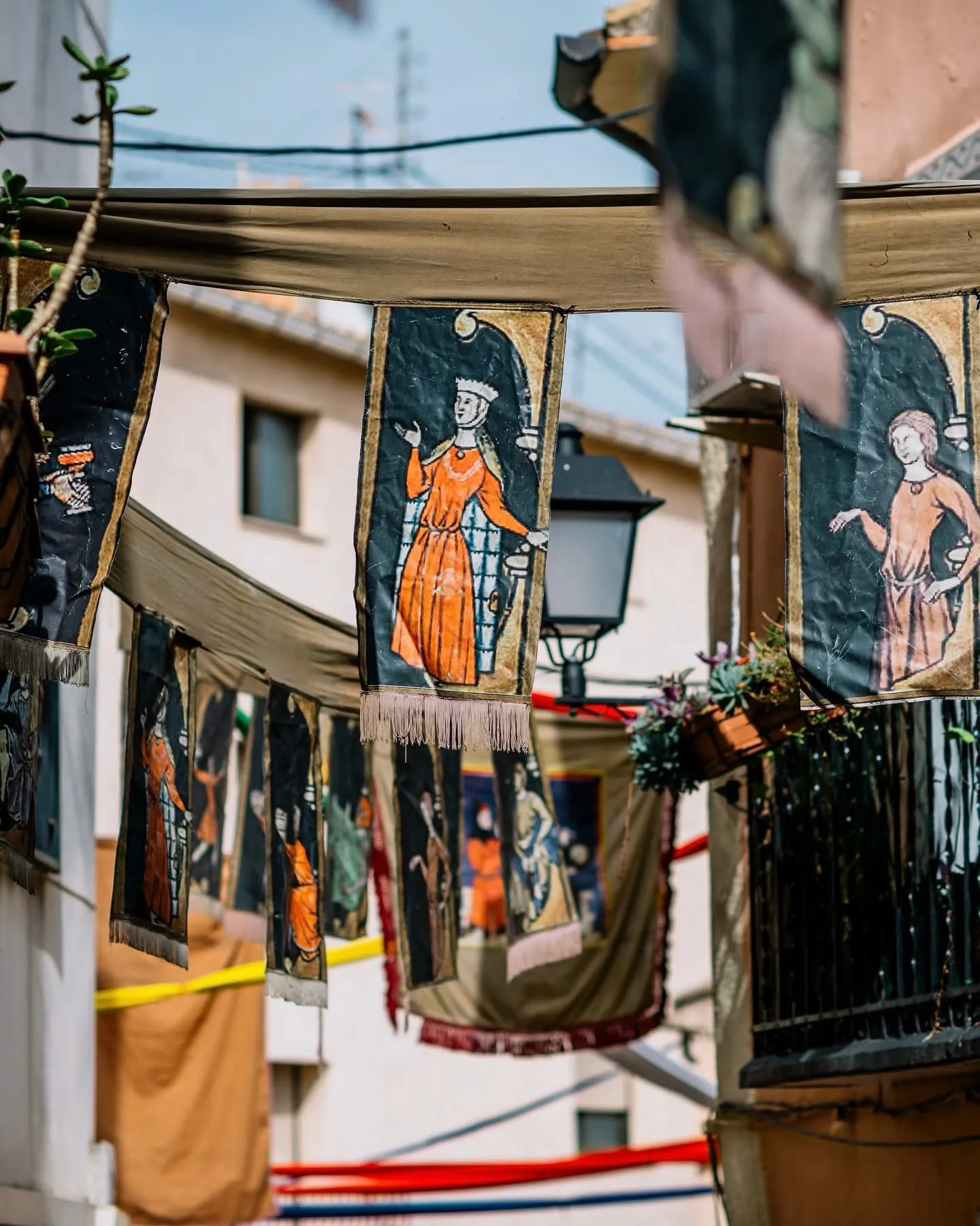 Medieval Banners Decorating the Old Town Hand-painted medieval-style banners hang across a street in Cocentaina’s historic centre during the annual fair.