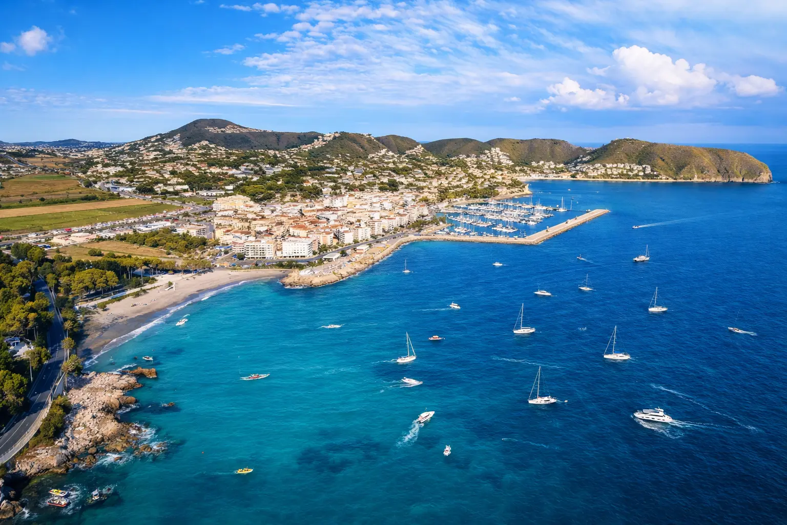 Moraira Coastline and Marina Aerial View on the Costa Blanca Aerial view of Moraira on the Costa Blanca showing the marina, turquoise sea, boats, and coastal town surrounded by hills