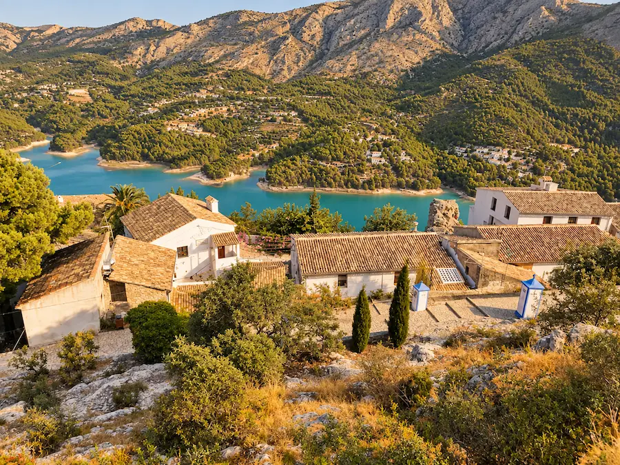 View of Guadalest village and its castle ruins above the turquoise reservoir in the Costa Blanca hinterland